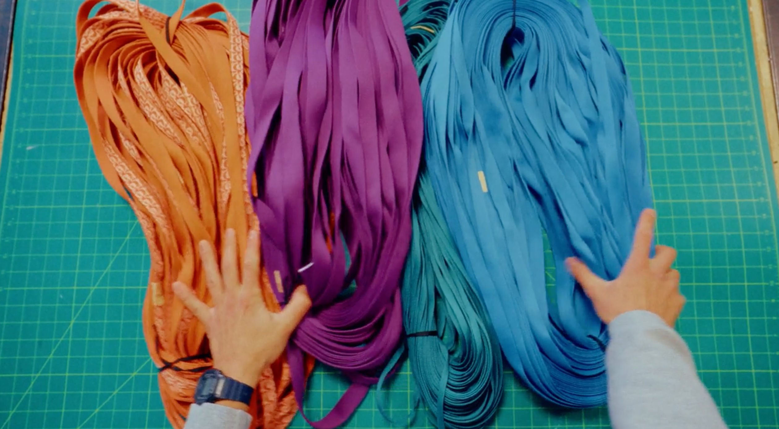 Hands sorting reclaimed textiles for circular design, material recovery, and product development at Public Thread.
